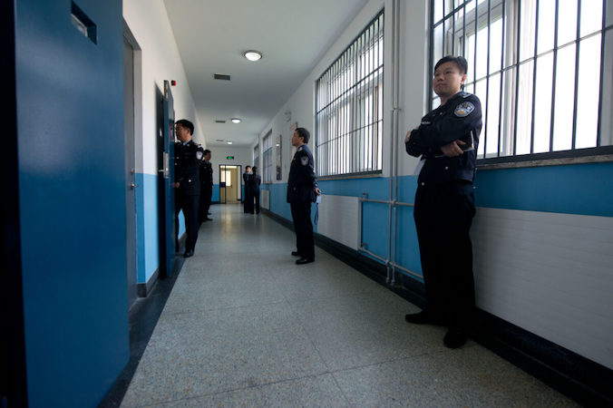 Strażnicy stoją na korytarzu w Ośrodku Detencyjnym nr 1 podczas oprowadzania po obiekcie zorganizowanego przez władze, Pekin, 25.10.2012 r. (Ed Jones/AFP via Getty Images)