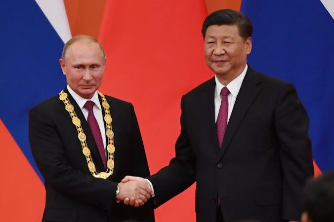 Przywódca Komunistycznej Partii Chin Xi Jinping (po prawej) gratuluje rosyjskiemu przywódcy Władimirowi Putinowi po wręczeniu mu Medalu Przyjaźni w Wielkiej Hali Ludowej w Pekinie 8.06.2018 r. (Greg Baker/AFP/Getty Images)
