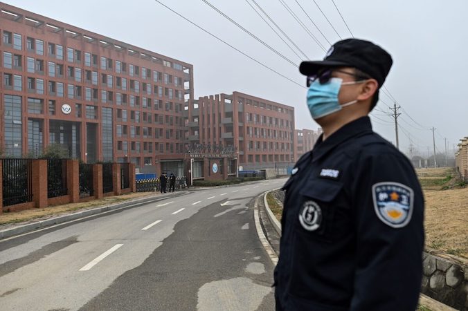 Pracownik ochrony stoi na straży, podczas gdy do Instytutu Wirusologii w Wuhan przybywa zespół Światowej Organizacji Zdrowia, WHO, mający zbadać pochodzenie COVID-19, Wuhan, prowincja Hubei w środkowych Chinach, 3.02.2021 r. (Hector Retamal/AFP via Getty Images)