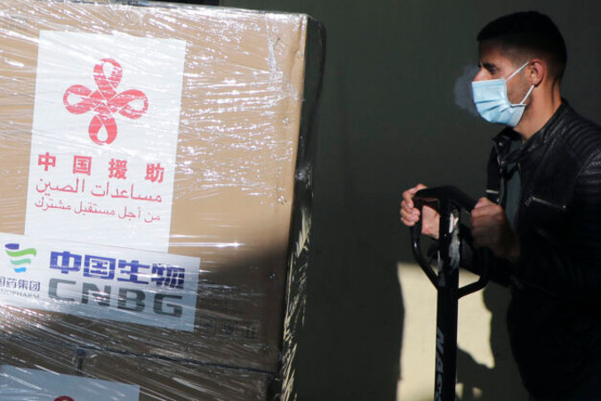 Palestyński robotnik rozładowuje dostawę szczepionek Sinopharmu przeciwko COVID-19, podarowanych przez Pekin, miasto Nablus na Zachodnim Brzegu Jordanu, 29.03.2021 r. (Jaafar Ashtiyeh/AFP via Getty Images)