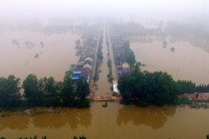 Widok z lotu ptaka ukazuje drzewa i domy zatopione przez powstałe w wyniku intensywnych deszczów wody powodziowe, które uderzyły w tamę na rzece Xiangyang w miasteczku Xinji, prefektura Yangzhou, prowincja Jiangsu, wschodnie Chiny, 6.07.2016 r. (STR/AFP/Getty Images)