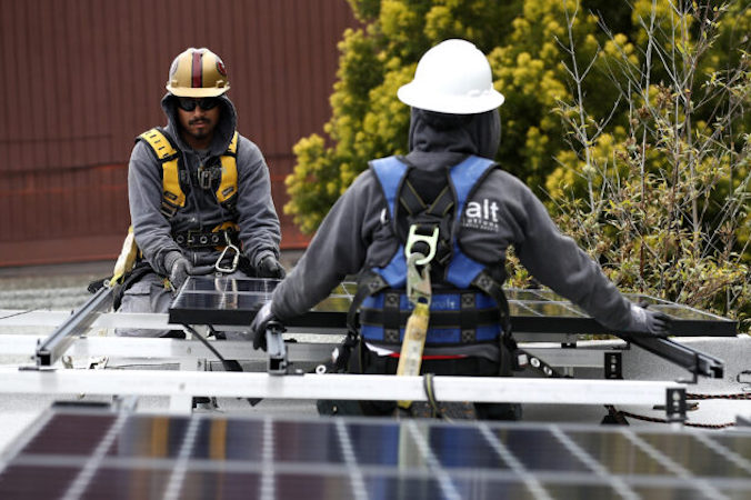 Robotnicy instalują panele słoneczne na dachu domu w San Francisco, Kalifornia, 9.05.2018 r. (Justin Sullivan / Getty Images)