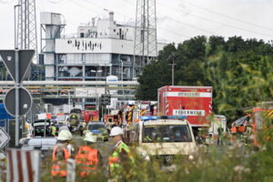 Wozy straży pożarnej i samochody policyjne stoją w pobliżu miejsca eksplozji w strefie przemysłu chemicznego Chempark, Leverkusen w Niemczech, 27.07.2021 r. (SASCHA STEINBACH/PAP/EPA)
