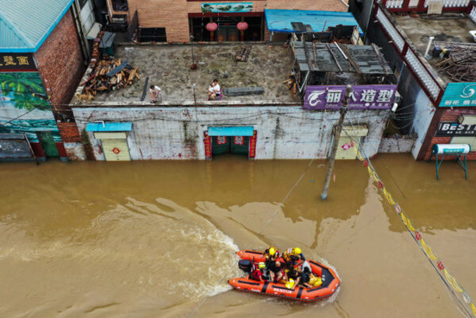 Ratownicy ewakuują mieszkańców po ulewnych deszczach w mieście Xinxiang, prowincja Henan w środkowych Chinach, 23.07.2021 r. (AFP via Getty Images)