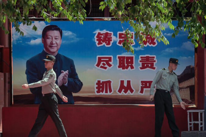 Żołnierze obok plakatu chińskiego przywódcy Xi Jinpinga przy wejściu do Zakazanego Miasta w Pekinie, 18.05.2020 r. (Nicolas Asfouri/AFP via Getty Images) 