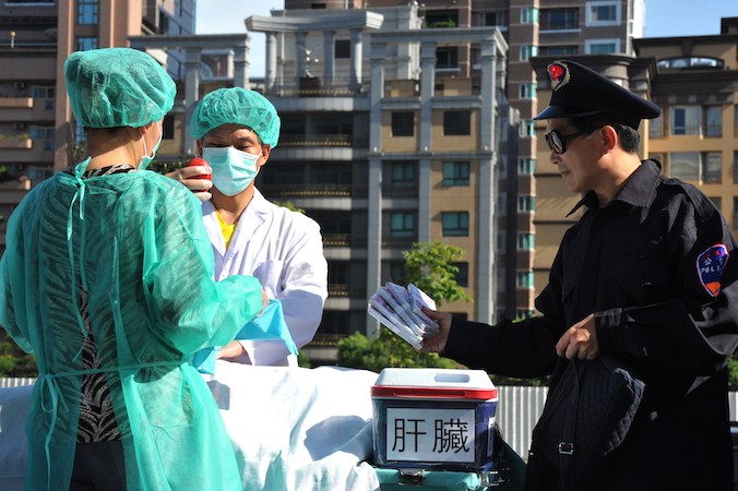 Zwolennicy duchowej praktyki Falun Gong odtwarzają scenę grabieży organów podczas demonstracji w Tajpej przeciwko prześladowaniom grupy przez Chiny, 20.07.2014 r. (Mandy Cheng/AFP via Getty Images)