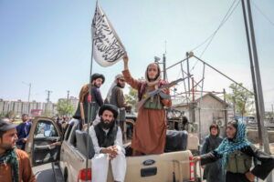 Talibowie stojący i siedzący z tyłu samochodu, Kabul w Afganistanie, 16.08.2021 r. (STRINGER/PAP/EPA)