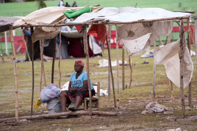 Kobieta odpoczywa na stadionie, gdzie urządzono obóz, po tym jak setki Haitańczyków straciło domy na skutek trzęsienia ziemi w ubiegłą sobotę, Les Cayes, Haiti, 17.08.2021 r. (Orlando Barria/PAP/EPA)