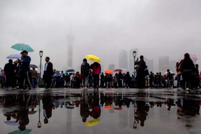 Turyści patrzą na panoramę Szanghaju w Dzielnicy Finansowej Lujiazui w Pudong, Chiny, 22.10.2018 r. (Johannes Eisele/AFP via Getty Images)