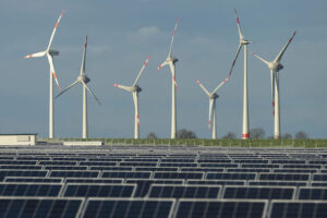 Turbiny wiatrowe stoją za farmą paneli fotowoltaicznych w pobliżu Werder, Niemcy, 30.10.2013 r. (Sean Gallup / Getty Images)