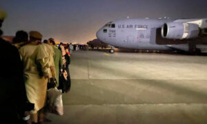 Afgańczycy ustawiają się w kolejce do samolotu wojskowego USA, który ma opuścić Afganistan, lotnisko wojskowe w Kabulu, 19.08.2021 r., po przejęciu Kabulu przez talibów (Shakib Rahmani/AFP via Getty Images)