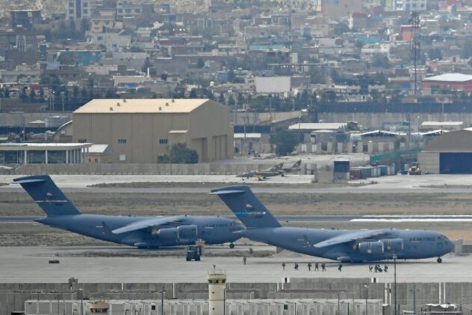 Żołnierze amerykańscy przechodzą przez płytę lotniska, aby wejść na pokład samolotu Sił Powietrznych USA na lotnisku w Kabulu, Afganistan, 30.08.2021 r. (Aamir Qureshi/AFP via Getty Images)