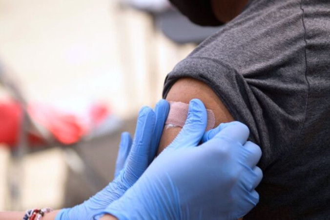 Pacjent otrzymuje opatrunek po podaniu pierwszej dawki szczepionki COVID-19 w mobilnym punkcie szczepień w Weingart East Los Angeles YMCA, Los Angeles, 7.08.2021 r. (Patrick T. Fallon/AFP via Getty Images)