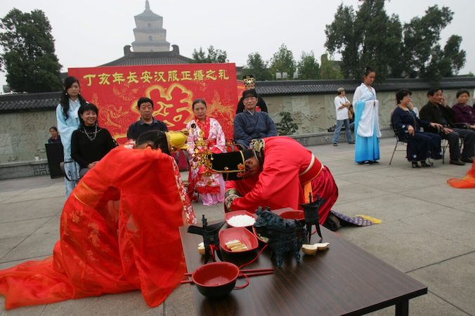 Nowożeńcy kłaniają się sobie nawzajem podczas ceremonii zaślubin w stylu Han, która ma miejsce na północnym placu Wielkiej Pagody Dzikich Gęsi w mieście Xi’an, prowincja Shaanxi w Chinach, 3.10.2007 r. (China Photos / Getty Images)