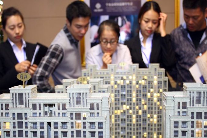 Klienci i agenci nieruchomości oglądają kilka modeli budynków na wystawie nieruchomości w Jiashan, prowincja Zhejiang, Chiny, fotografia niedatowana (AFP/AFP/Getty Images)