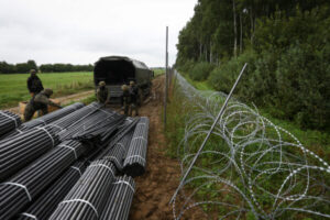 Polscy żołnierze rozładowują materiały do budowy ogrodzenia z drutu kolczastego na granicy z Białorusią, Zubrzyca Wielka k. Białegostoku, 26.08.2021 r. (Jaap Arriens/AFP via Getty Images)