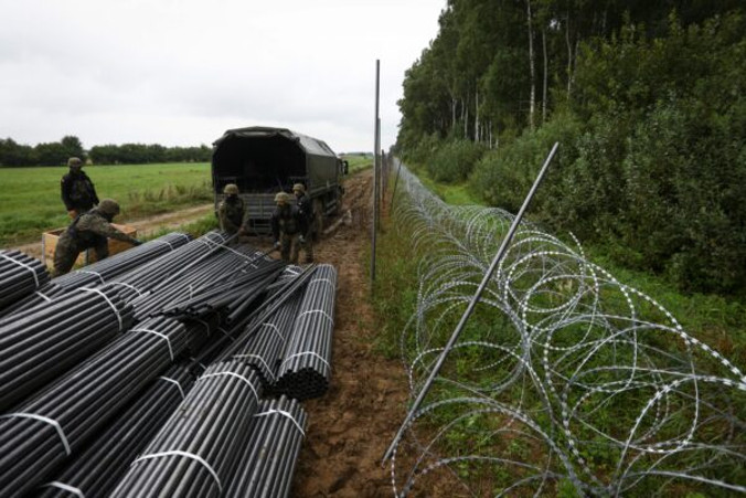 Zdjęcie ilustracyjne. Polscy żołnierze rozładowują materiały do budowy ogrodzenia z drutu kolczastego na granicy z Białorusią, Zubrzyca Wielka k. Białegostoku, 26.08.2021 r. (Jaap Arriens/AFP via Getty Images)
