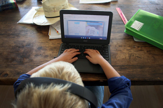 Dziecko wykonuje pracę domową na komputerze. Zdjęcie ilustracyjne (Lisa Maree Williams / Getty Images)