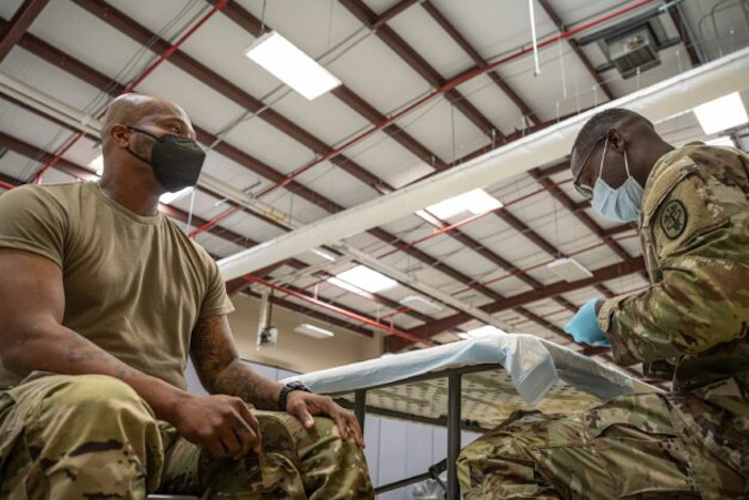 Członek amerykańskich służb przygotowuje się do podania szczepionki przeciw COVID-19, Fort Knox w Kentucky, USA, 9.09.2021 r. (Jon Cherry / Getty Images)