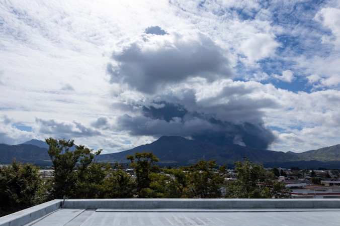 Czarne chmury (w tle) po erupcji góry Aso w prefekturze Kumamoto, południowo-zachodnia Japonia, 20.10.2021 r., zdjęcie udostępnione przez Urząd Miasta Aso, otrzymane za pośrednictwem Jiji Press (ASO CITY HALL HANDOUT/PAP/EPA)