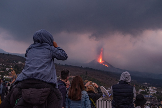 Ludzie obserwują wulkan Cumbre Vieja podczas kolejnego dnia erupcji na wyspie La Palma w archipelagu Wysp Kanaryjskich, Hiszpania, 29.10.2021 r. (MIGUEL CALERO/PAP/EPA)