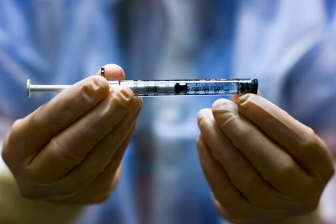 Technik farmacji trzyma dawkę szczepionki przeciwko COVID-19 przed podaniem jej w badaniu klinicznym, Aurora w stanie Kolorado, USA, 15.12.2020 r. (Michael Ciaglo / Getty Images)