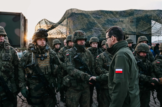 Premier Mateusz Morawiecki podczas spotkania z żołnierzami oraz funkcjonariuszami służb biorących udział w zabezpieczaniu polskiej granicy z Białorusią w rejonie Kuźnicy, 9.11.2021 r. (Adam Guz/KPRM/PAP)