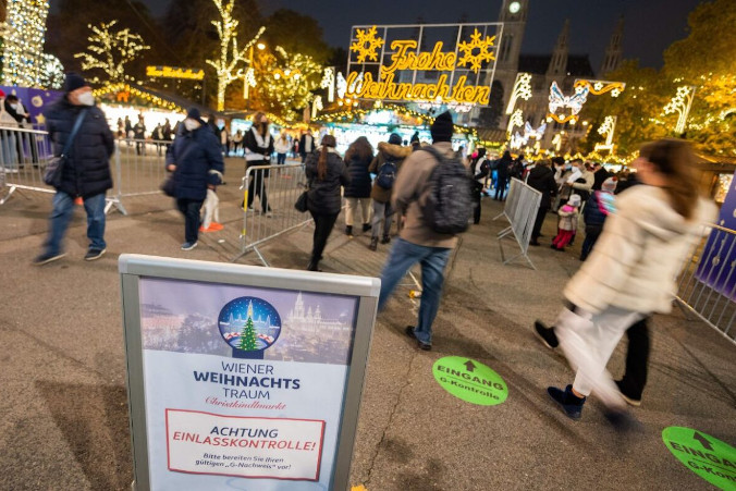 Tablica ostrzegająca odwiedzających o kontroli ich statusu – zaszczepionego lub wyleczonego z COVID-19 – przy wejściu na „Christkindlmarkt”, tradycyjny wiedeński jarmark bożonarodzeniowy, plac przed Ratuszem w Wiedniu, Austria, 12.11.2021 r. (Georg Hockmuth/APA/AFP via Getty Images)