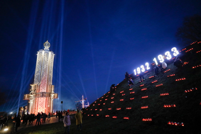 Ukraińcy zapalają znicze podczas ceremonii upamiętniającej przy Pomniku Ofiar Wielkiego Głodu, Kijów, Ukraina, 27.11.2021 r. (SERGEY DOLZHENKO/PAP/EPA)