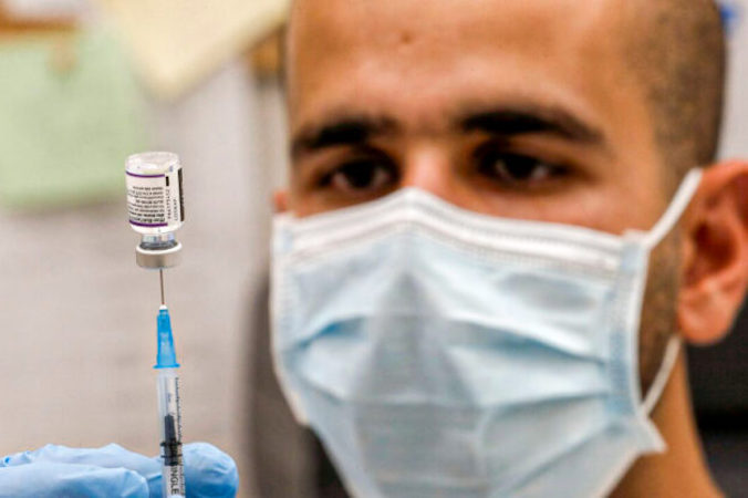 Pracownik służby zdrowia w Izraelu przygotowuje dawkę szczepionki Pfizer-BioNTech (Ahmad Ghababli/AFP via Getty Images)