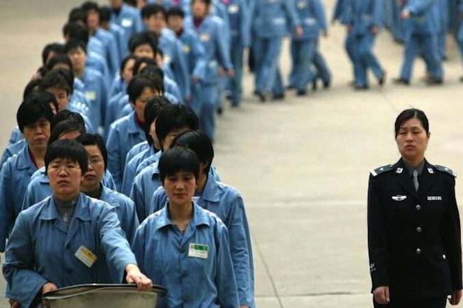 Więźniarki przechodzą obok eskorty policyjnej podczas dnia otwartego w więzieniu w Nanjing, 2005 r. (STR/AFP/Getty Images)