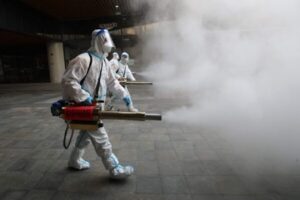 Członkowie personelu ubrani w środki ochrony osobistej rozpylają środek dezynfekujący na zewnątrz centrum handlowego w Xi’an, <a href="https://www.theepochtimes.com/t-china">Chiny</a>, 11.01.2022 r. (STR/AFP via Getty Images)
