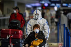 Pasażerowie w maskach przybywają na międzynarodowe lotnisko Pudong w Szanghaju, 19.03.2020 r. (Hector Retamal/AFP via Getty Images)