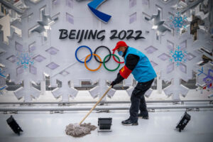 Wolontariusz czyści rzeźbę poświęconą Zimowym Igrzyskom Olimpijskim 2022 w Pekinie, Chiny, 23.01.2022 r. (Andrea Verdelli / Getty Images)