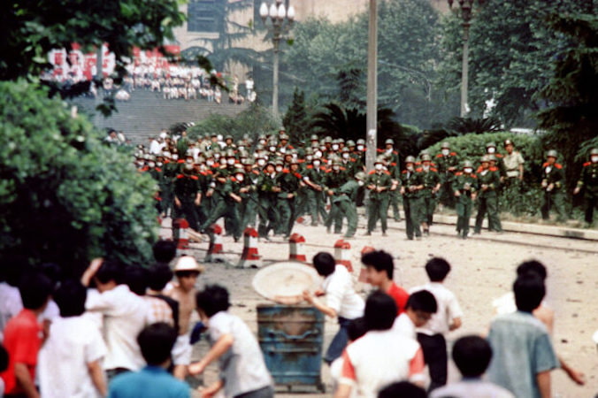 Chińscy obywatele i studenci z Chengdu, stolicy prowincji Syczuan, rzucają kamieniami w żołnierzy podczas zamieszek po ogłoszeniu stanu wojennego w tym mieście. Serię prodemokratycznych protestów wywołała śmierć byłego przywódcy partii komunistycznej Hu Yaobanga 15 kwietnia. W pokazie siły przywódcy Chin dali upust swojej wściekłości i frustracji wobec studenckich dysydentów i ich zwolenników, 4.06.1989 r. (-/AFP via Getty Images)