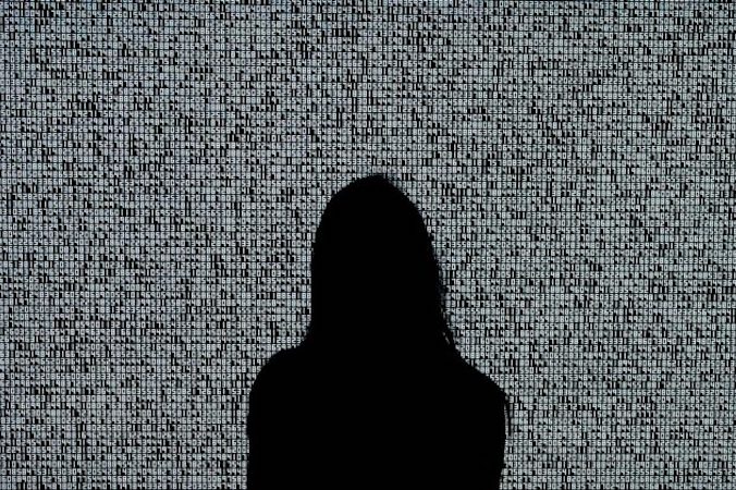 Kobieta patrzy na obraz NFT Ryoji Ikedy zatytułowany „A Single Number That Has 10,000,086 Digits” podczas pokazu dla mediów w domu akcyjnym Sotheby’s w Nowym Jorku, 4.06.2021 r. (Timothy A. Clary/AFP via Getty Images)