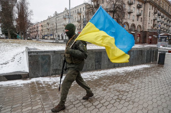 Ukraiński żołnierz niesie ukraińską flagę narodową w centrum Kijowa, Ukraina, 1.03.2022 r. (ZURAB KURTSIKIDZE/PAP/EPA)
