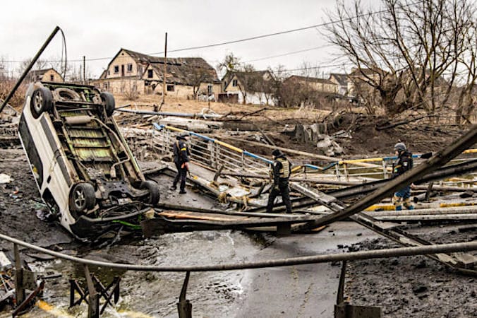 Ukraińscy żołnierze przechodzą przez zniszczony most w pobliżu linii frontu podczas walk w Irpieniu, obwód kijowski, Ukraina, 3.03.2022 r. (Chris McGrath / Getty Images)