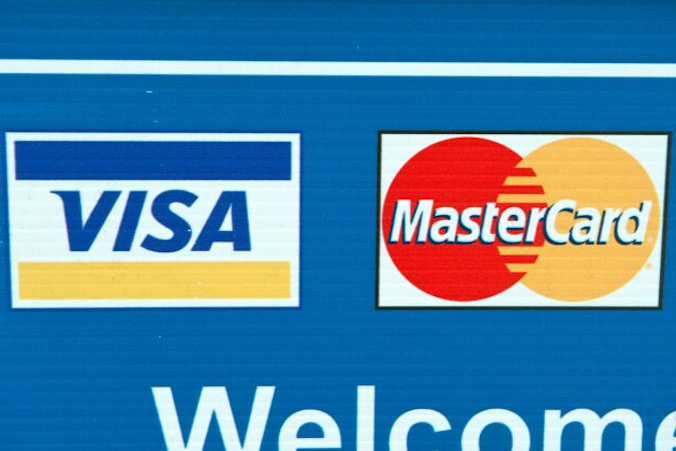 Logo kart kredytowych Visa i Mastercard na tablicy w Waszyngtonie, 30.03.2012 r. (Nicholas Kamm/AFP via Getty Images)