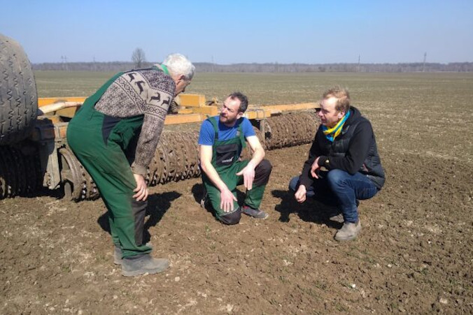 Na zdjęciu ilustracyjnym niemieccy rolnicy Tim Nandelstädt (pośrodku) i Torben Reelfs (po prawej) oglądają pole w swoim gospodarstwie we wsi Derżiw (Derżów), rejon stryjski, obwód lwowski, zachodnia Ukraina, 23.03.2022 r. (Tim Nandelstaedt/AFP via Getty Images)