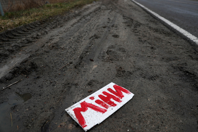 Tabliczka z napisem po ukraińsku „Miny” w pobliżu wioski w „szarej strefie” linii frontu, obwód kijowski, Ukraina, 30.03.2022 r. (ATEF SAFADI/PAP/EPA)