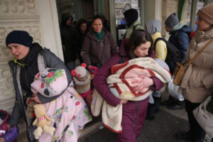 Kobiety i dzieci, które uciekły z ogarniętej wojną Ukrainy, wychodzą z dworca głównego w Przemyślu, w pobliżu granicy z Ukrainą, 9.03.2022 r. (Sean Gallup / Getty Images)