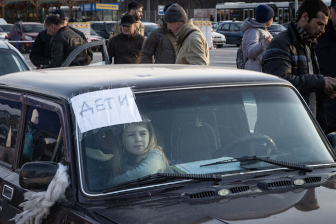 Zdjęcie ilustracyjne. Dziewczynka czeka w samochodzie w punkcie ewakuacyjnym w konwoju samochodów i autobusów przewożących setki osób ewakuowanych z Mariupola i Melitopola, Zaporoże w Ukrainie, 25.03.2022 r. (Chris McGrath / Getty Images)