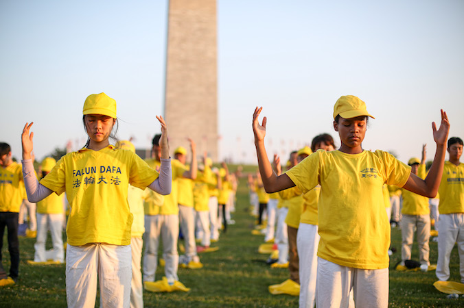 Praktykujący Falun Gong wykonują ćwiczenia podczas wydarzenia upamiętniającego 22. rocznicę rozpoczęcia prześladowań Falun Gong przez chiński reżim, Waszyngton, 16.07.2021 r. (Samira Bouaou / The Epoch Times)