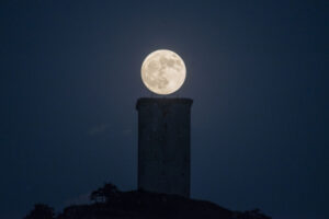 Truskawkowy księżyc obserwowany obok Wieży Da Pena w Xinzo de Limia w północnej Hiszpanii, 13.06.2022 r. (Brais Lorenzo/PAP/EPA)