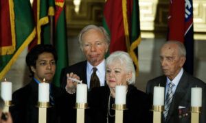 Senator Joseph Lieberman (z tyłu) patrzy, jak Etta Katz zapala świecę pamięci, a Józef Walaszczyk (po prawej) przygląda się ceremonii podczas Dni Pamięci Narodowego Muzeum Holokaustu, Rotunda Kapitolu, Stany Zjednoczone, 23.04.2009 r. (Paul J. Richards/AFP via Getty Images)