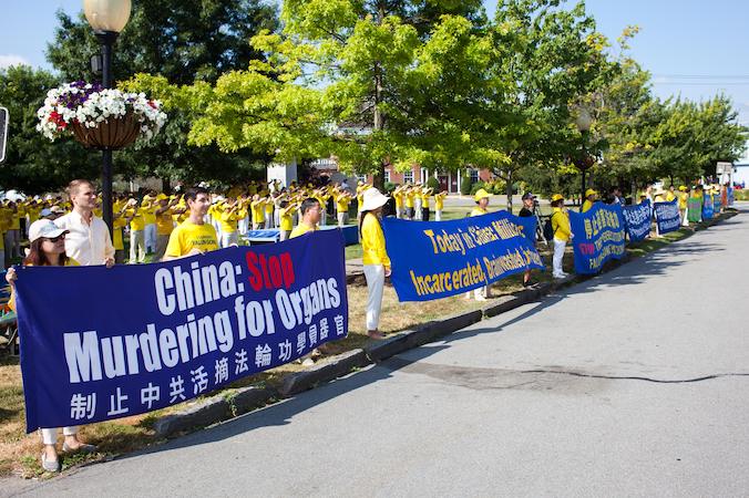 Zwolennicy Falun Gong trzymają transparenty wzdłuż drogi w Goshen, stan Nowy Jork, 17.07.2022 r. Kilkuset wyznawców duchowej praktyki zebrało się w miasteczku, aby upamiętnić 23. rocznicę rozpoczęcia prześladowań Falun Gong w Chinach przez Komunistyczną Partię Chin (Petr Svab / The Epoch Times)