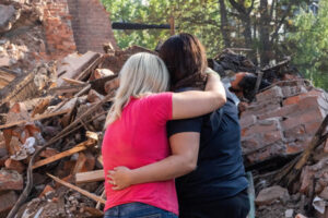 Kobiety przed gruzami ich zniszczonego przez rosyjski pocisk domu w Charkowie, 18.08.2022 r. (Mykola Kalyeniak / PAP)