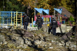 Policjanci stoją w pobliżu placu zabaw dla dzieci po ostrzale w centrum Kijowa, Ukraina, 10.10.2022 r. (OLEG PETRASYUK/PAP/EPA)