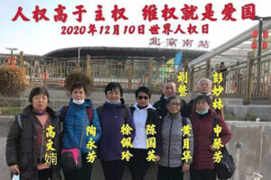 W Dniu Praw Człowieka kilka osób z Szanghaju składających petycje zrobiło sobie grupowe zdjęcie na zewnątrz dworca kolejowego w Pekinie, po tym jak przyjechali złożyć petycję 10 grudnia 2020 roku. Napis ponad grupą głosi: „Prawa człowieka są ponad władzą; Obrona praw jest patriotyczna” (dzięki uprzejmości rozmówców)